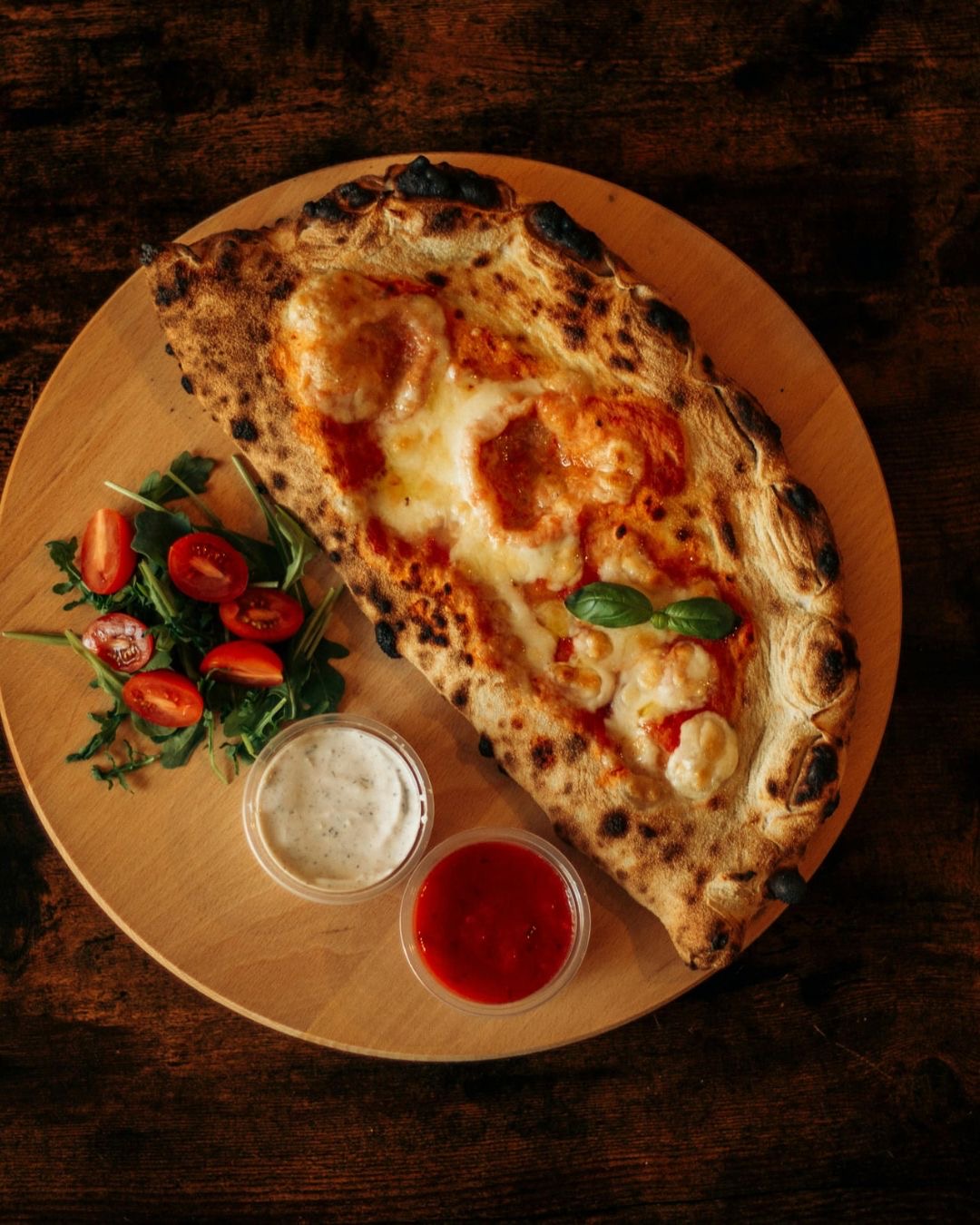 Folded calzone with side salad and dips