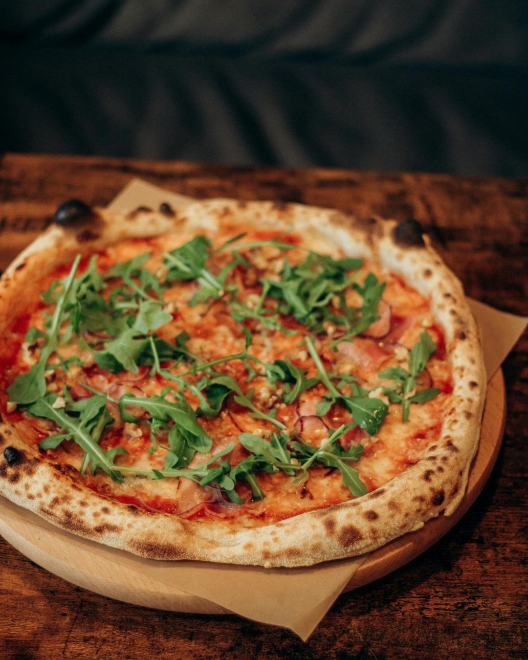 Pizza topped with prosciutto and fresh rocket