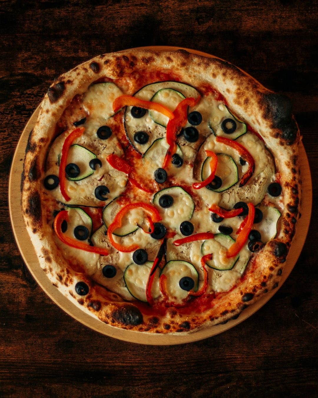 Vegetarian pizza with zucchini, peppers and black olives